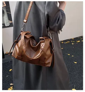 Brown PU leather Boston bag shown on model in grey coat for a casual commuting style