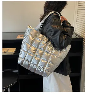 Borsa tote trapuntata argento indossata dalla modella con finitura metallica e capiente