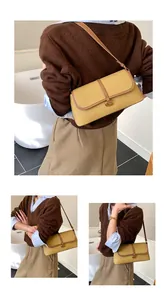 Détails du sac baguette jaune moutarde avec boucle C dorée et finitions en cuir texturé