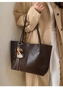 Macro shot of dark coffee tote bag with vertical stitching and leopard print heart charm