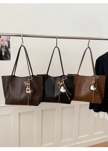 Detailed view of three vintage tote bags with heart-shaped mirror and leopard print charms