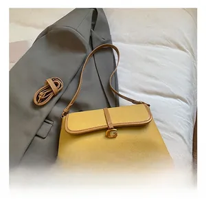 Détail du sac baguette en cuir jaune avec boucle métallique en forme de G dorée vintage