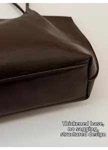 Detail of reinforced bottom on dark brown tote bag showing sturdy structure and texture