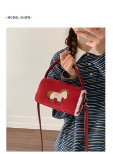 Close-up of red suede baguette bag with horse embroidery and white faux fur trim details