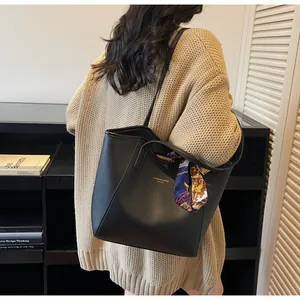 Détail d'un grand sac cabas noir avec foulard en soie imprimé et lettrage doré chic