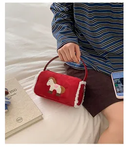 Detail of red plush baguette bag with horse embroidery and white faux shearling trim