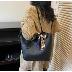 Détail du sac cabas noir en similicuir avec foulard en soie et lettrage doré