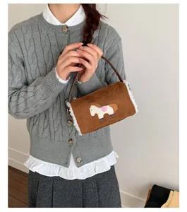 Detailed view of brown faux suede baguette bag featuring a cute pony embroidery patch