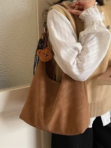 Bruine hobo tas van suède met teddybeertje hanger en gestreepte sjaal accenten