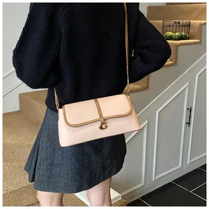 Détail du sac à rabat rectangulaire beige avec boucle G dorée et bordure en cuir