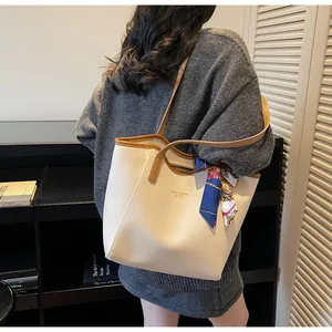 Détail du sac cabas minimaliste crème avec lanières marron et foulard décoratif en soie