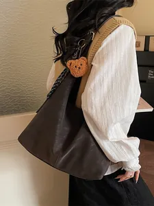 Donkerbruine lederen tote bag met teddybeer hanger en gestipte zijden sjaal
