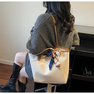 Détail d'un grand sac cabas crème avec bordure marron et foulard en soie imprimé décoratif
