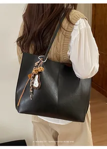 Lifestyle shot of large black tote bag with leopard print charm for commute