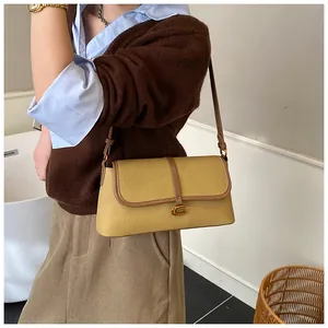 Détail du sac baguette en cuir jaune moutarde avec liseré marron et boucle dorée G