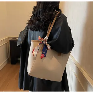 Détail du cabas minimaliste avec poignées contrastées et foulard floral décoratif