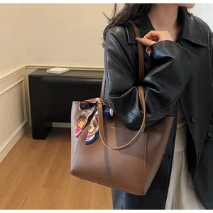 Détail d'un sac cabas marron foncé avec foulard en soie et texte de mode imprimé
