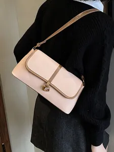 Sac baguette chic beige rose avec boucle G dorée porté à l'épaule pour un look élégant
