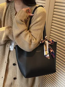Sac cabas minimaliste en similicuir noir avec un foulard en soie imprimé sur la poignée