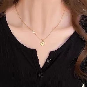 Elegant gold snowflake pendant necklace on a model wearing a black knitted top