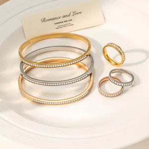 Detailed arrangement of gold and silver titanium steel zircon bracelets and rings on a tray