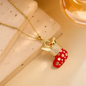 Close-up of a festive red Christmas stocking pendant with gold details and zircons