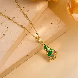 Detailed macro view of golden Christmas tree pendant with green enamel and colorful crystals