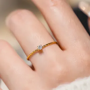 Λήψη macro δαχτυλιδιού 18k με σφυρήλατη υφή και έναν μικρό διαμαντένιο πολύτιμο λίθο