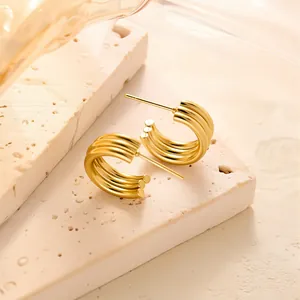 Detailansicht goldener dreilagiger geometrischer C-Ohrstecker auf Stein-Display