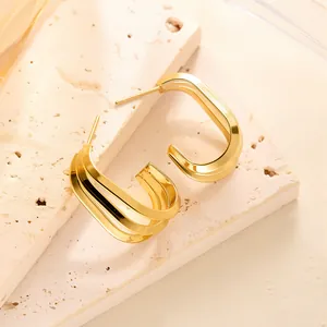 Detailansicht goldener geometrischer Ohrringe in dreilagiger Optik auf Stein
