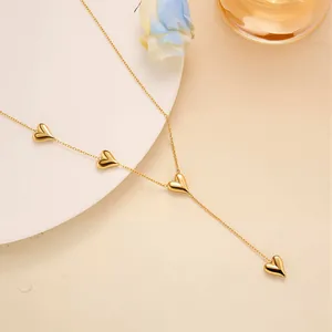 Detailed view of a gold Y-shaped heart necklace with polished heart-shaped pendants