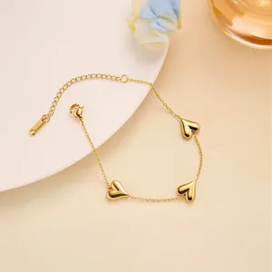 Close-up of golden multi-heart titanium bracelet with lobster clasp and extension chain