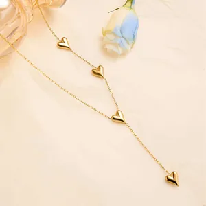 Detail of gold Y-shaped heart necklace with dangling polished heart pendants on links
