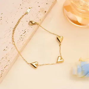 Detail of gold heart pendant bracelet with polished charms and adjustable lobster clasp