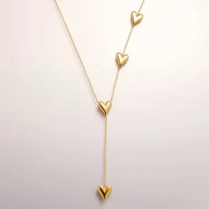 Detail of Y-shaped gold-plated necklace featuring vertical polished 3D heart pendants