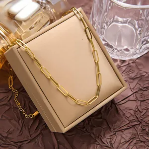 Détail du collier chaîne trombone doré poli sur un présentoir à bijoux de luxe