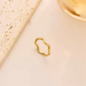 Makroaufnahme eines minimalistischen goldenen Wellenrings aus Edelstahl mit Politur