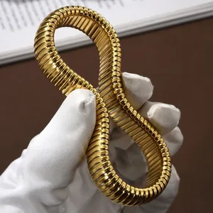 Elegante bracciale Tubogas in acciaio inossidabile dorato tenuto da mani guantate