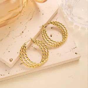Detail von geometrischen gedrehten Creolen mit 18 Karat Goldbeschichtung und Textur