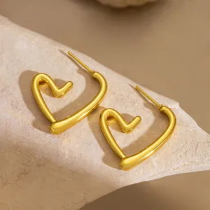 Λήψη macro από γυαλισμένα σκουλαρίκια καρδιά 18k σε φόντο από φυσική πέτρα