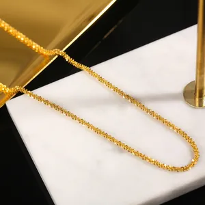 Élégant collier en acier titane plaqué or 18k sur un présentoir en marbre blanc