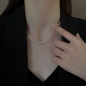Gros plan d'un collier tennis argenté scintillant sur un mannequin en blazer noir