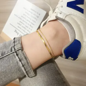 Double-layered gold titanium anklet featuring snake and box chains on woman's ankle