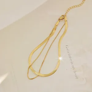 Detail of double-layer golden snake and box chain anklet with secure lobster clasp