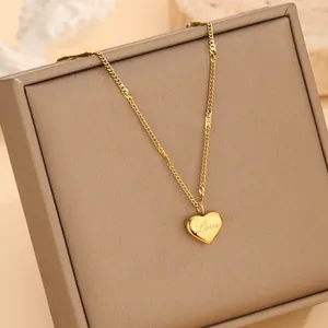 Poliertes 18k Gold Herz Halskette mit Love Gravur auf einer Schmuckschatulle