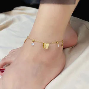 Detailed close-up of gold butterfly anklet with sparkling zircon stones worn on ankle