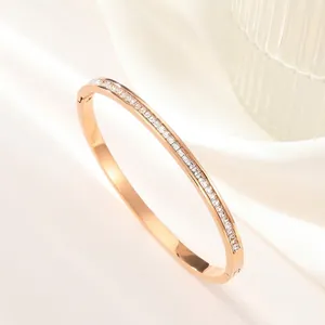 Detailed macro view of rose gold titanium bangle featuring square-cut zircon stones