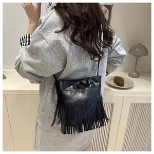 Sac bandoulière à longues franges porté par le modèle pour une vue de taille et style quotidien