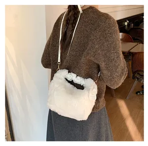 Detailansicht der weißen Plüschtasche mit gerafftem Ledergriff und goldener Hardware