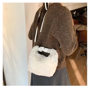 Detail der weißen Kunstpelz-Handtasche mit gerafftem Griff und Dekofänger